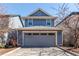 Charming blue two-story home with a gray garage door and well-maintained landscaping at 3353 Wabash St, Denver, CO 80238
