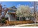 Charming two-story home with a red door, complemented by a lovely blooming tree at 3353 Wabash St, Denver, CO 80238