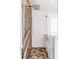 Close-up of modern bathroom shower with wood accent wall, white subway tiles, and glass door at 3353 Wabash St, Denver, CO 80238