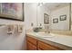 Cozy bathroom boasting a white sink, light brown vanity and tiled countertop, complemented by artistic decor at 758 Chimney Creek Dr # C, Golden, CO 80401