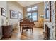 Spacious living room with hardwood floors, piano, and natural light from multiple windows at 758 Chimney Creek Dr # C, Golden, CO 80401