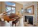 Elegant living room with piano, stone fireplace, and beautiful natural light from the windows at 758 Chimney Creek Dr # C, Golden, CO 80401