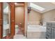 Elegant bathroom with a soaking tub, neutral tile, and a framed mirror at 758 Chimney Creek Dr # C, Golden, CO 80401