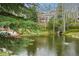 Scenic view of a tranquil pond, lush greenery, and a home in the background at 758 Chimney Creek Dr # C, Golden, CO 80401