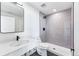 Modern bathroom features a white vanity, large shower with gray tile, and black hardware at 1416 Pierce St, Lakewood, CO 80214