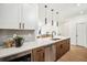 Close-up of a kitchen island with modern fixtures, lighting, and countertops at 1416 Pierce St, Lakewood, CO 80214