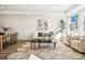 Open-concept living room boasts large windows, stylish seating, and a unique floral-patterned rug at 1416 Pierce St, Lakewood, CO 80214