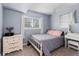 Bright bedroom with light blue walls, two windows, a dresser, and carpet at 21524 E Powers Pl, Centennial, CO 80015