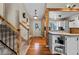 Welcoming entryway with hardwood floors, a staircase with carpeted steps, and a view into the connected kitchen at 21524 E Powers Pl, Centennial, CO 80015