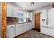 Traditional kitchen features white cabinets, brick backsplash, stainless steel appliances, and hardwood floors at 21524 E Powers Pl, Centennial, CO 80015