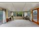 Spacious sunroom filled with natural light, neutral carpeting and a view of the landscaped backyard at 21524 E Powers Pl, Centennial, CO 80015