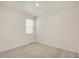 This bedroom features neutral carpet, baseboard trim, and a bright window at 27694 E Byers Ave, Aurora, CO 80018