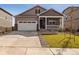 Charming home featuring a covered porch, stone accents, a well-kept lawn, and a two-car garage at 27694 E Byers Ave, Aurora, CO 80018