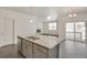 Bright, open floor plan featuring a kitchen island with granite counters, hardwood floors, and stainless appliances at 27694 E Byers Ave, Aurora, CO 80018