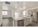 Bright open floor plan with kitchen island including pendant lights and stainless steel appliances at 27694 E Byers Ave, Aurora, CO 80018