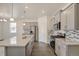 Bright modern kitchen with stainless steel appliances, gray cabinets and granite island with hardwood flooring at 27694 E Byers Ave, Aurora, CO 80018