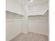 This walk-in closet features neutral carpet and multiple shelves for storage at 27694 E Byers Ave, Aurora, CO 80018