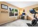 Bright bedroom featuring large window, home office setup, and exercise bike at 2795 Signal Creek Dr, Thornton, CO 80241