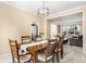 Open-concept dining room featuring a dark wood table, neutral paint, plush carpeting, and access to the living room and kitchen at 2795 Signal Creek Dr, Thornton, CO 80241