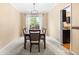 Formal dining room featuring a modern light fixture, neutral paint, plush carpeting, and a dark wood table with padded chairs at 2795 Signal Creek Dr, Thornton, CO 80241
