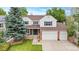 Charming two-story home featuring a well-manicured lawn, a two-car garage, and a welcoming front porch with porch swings at 2795 Signal Creek Dr, Thornton, CO 80241