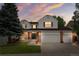 Charming two-story home featuring a well-manicured lawn, a two-car garage, and a welcoming front porch with porch swings at 2795 Signal Creek Dr, Thornton, CO 80241