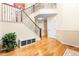 Inviting foyer featuring gleaming hardwood floors, a staircase with wrought iron railings, and a bench with storage baskets at 2795 Signal Creek Dr, Thornton, CO 80241
