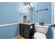 Stylish half bathroom with blue walls, granite countertop vanity, and modern toilet at 2795 Signal Creek Dr, Thornton, CO 80241