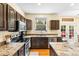 A kitchen featuring granite countertops, stainless appliances, island, and backyard access at 2795 Signal Creek Dr, Thornton, CO 80241
