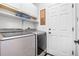 Practical laundry room with modern stainless steel washer, dryer, and convenient storage shelves at 2795 Signal Creek Dr, Thornton, CO 80241