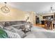 Inviting living room featuring a plush gray sectional sofa and open access to the modern kitchen at 2795 Signal Creek Dr, Thornton, CO 80241