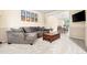 Comfortable living room featuring plush carpeting, a large sectional sofa, and a decorative coffee table next to the dining room at 2795 Signal Creek Dr, Thornton, CO 80241