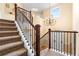 Elegant staircase with carpeted steps, iron railings, and decorative chandelier lighting at 2795 Signal Creek Dr, Thornton, CO 80241
