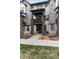 Townhome exterior featuring gray and white siding, brick accents, and covered balcony at 1312 Independence St # 3, Lakewood, CO 80215