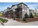 Exterior view of gray and white townhomes with brick accents and covered patios at 1312 Independence St # 3, Lakewood, CO 80215