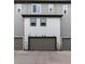 Exterior view of townhomes with a garage doors and gray siding and white trim at 1312 Independence St # 3, Lakewood, CO 80215