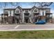 Townhome complex with brick and siding exterior, multiple stories, and a blue car parked outside at 1312 Independence St # 3, Lakewood, CO 80215