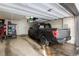 Spacious garage featuring ample storage, overhead racks, and a parked truck at 1312 Independence St # 3, Lakewood, CO 80215
