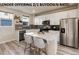 Bright kitchen features stainless appliances, white cabinets, tile backsplash, and a spacious quartz island at 1312 Independence St # 3, Lakewood, CO 80215