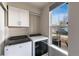 Bright laundry room with a modern washer and dryer, a window, and a storage cabinet at 1312 Independence St # 3, Lakewood, CO 80215