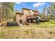Backyard view featuring a deck, slide, patio with hot tub, and lush trees at 17540 Caribou Dr, Monument, CO 80132