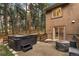 Backyard patio with a hot tub, seating area, and mature trees offering privacy at 17540 Caribou Dr, Monument, CO 80132