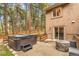 Backyard patio with a hot tub, seating area, and mature trees offering privacy at 17540 Caribou Dr, Monument, CO 80132