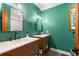 Unique bathroom featuring double vanity sinks and green wall paint at 17540 Caribou Dr, Monument, CO 80132