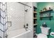 This bathroom features white subway tile with a white tub and green accent walls at 17540 Caribou Dr, Monument, CO 80132