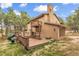 Exterior of home showcasing a deck with slide, patio with hot tub, and mature trees at 17540 Caribou Dr, Monument, CO 80132