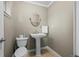 Half bathroom featuring pedestal sink, neutral paint, and modern toilet at 5320 W 62Nd Ave, Arvada, CO 80003