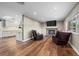 Cozy living room with a brick fireplace, wood floors, and comfortable leather chairs at 5320 W 62Nd Ave, Arvada, CO 80003