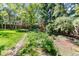 Picturesque backyard with a swing set, lush garden, mature trees, and a storage shed, perfect for outdoor enjoyment at 879 S Cole Dr, Lakewood, CO 80228