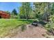 Expansive backyard with a lush lawn, mature trees, and garden boxes, perfect for outdoor activities and gardening at 879 S Cole Dr, Lakewood, CO 80228